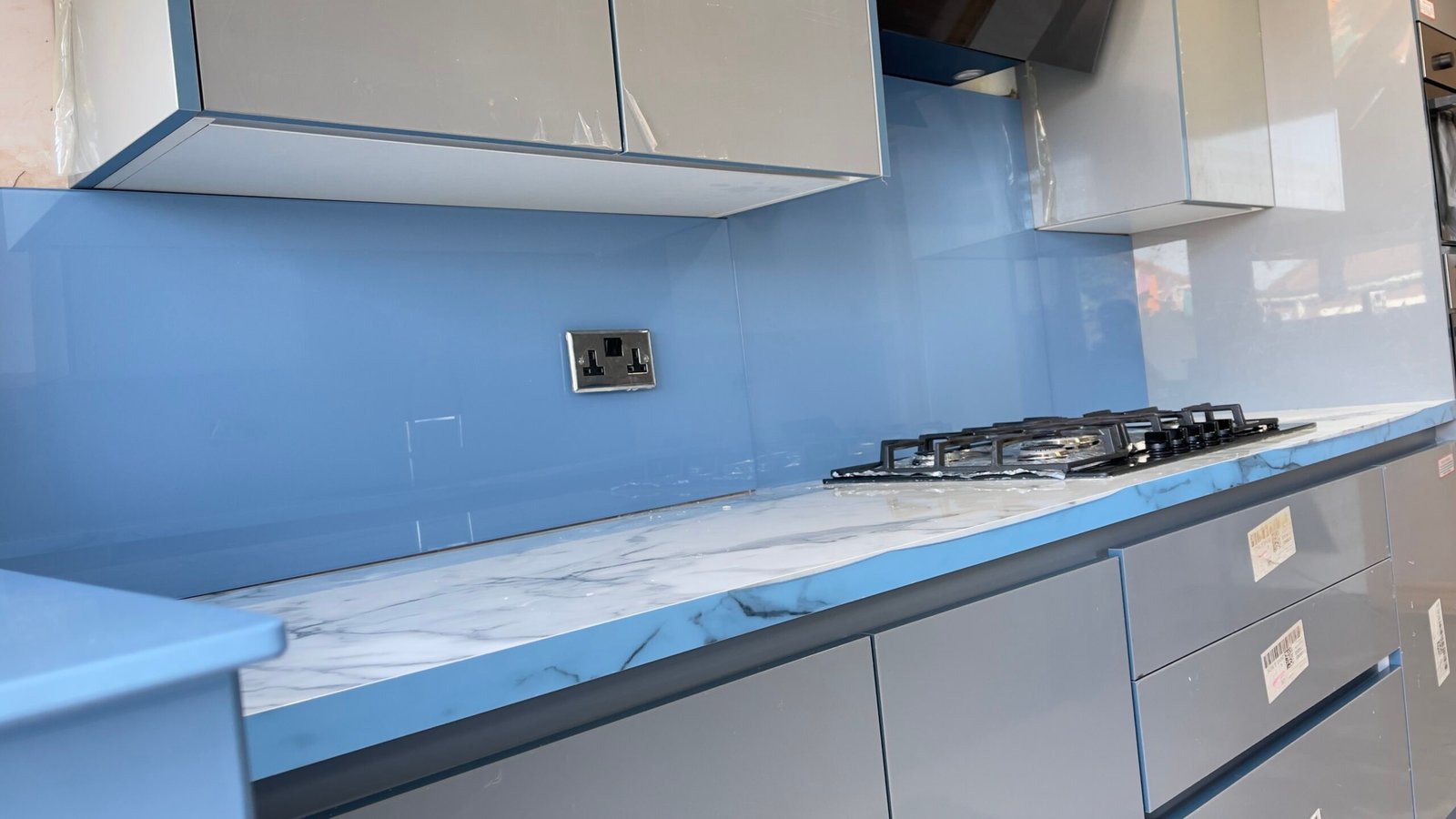 Grey kitchen with sky blue splashback